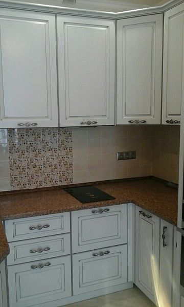 Белая угловая кухня с коричневой столешницей