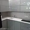 Угловая кухня с серыми глянцевыми шкафами и белой столешницей - фото 1