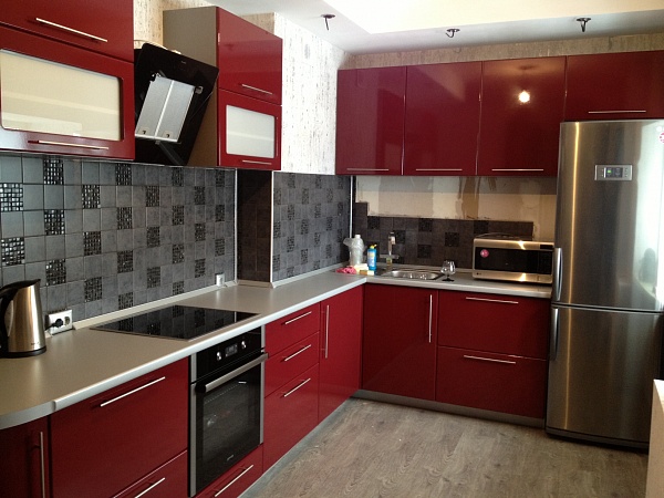 Угловая кухня бордового цвета с функциональными шкафами